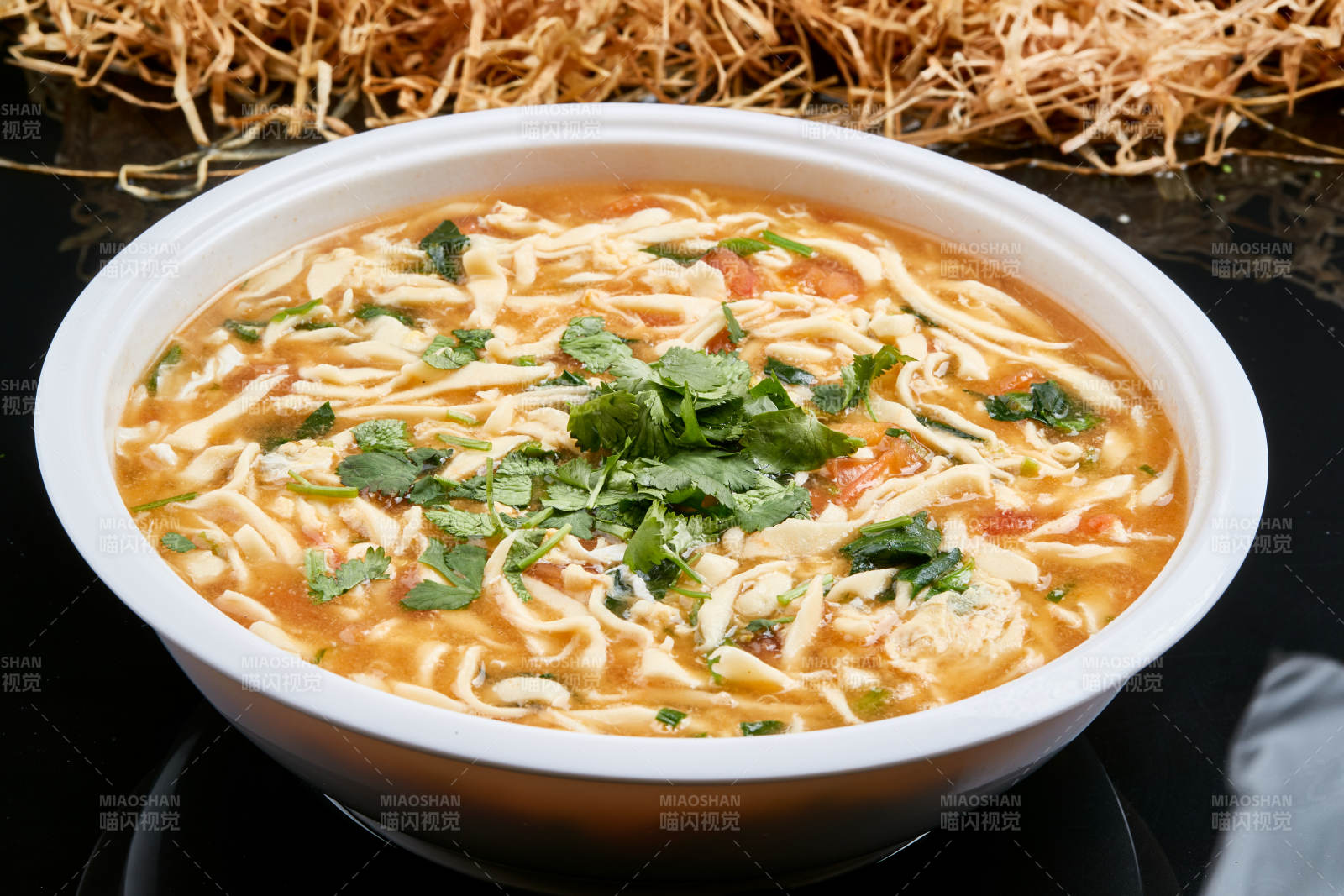 白色瓷盘装的西红柿鸡蛋白面拨鱼汤图片