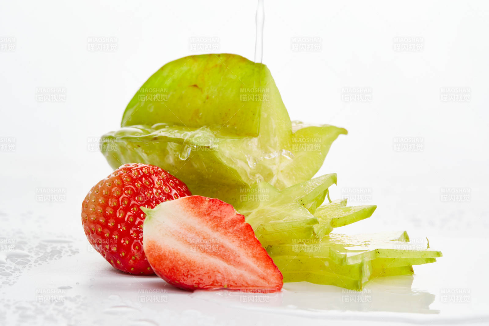 白色背景上摆放的新鲜洋桃和草莓及切片图片