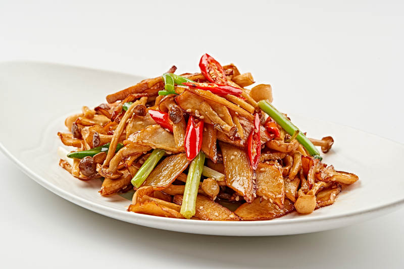 白色瓷盘装的香辣干煸山珍菌图片