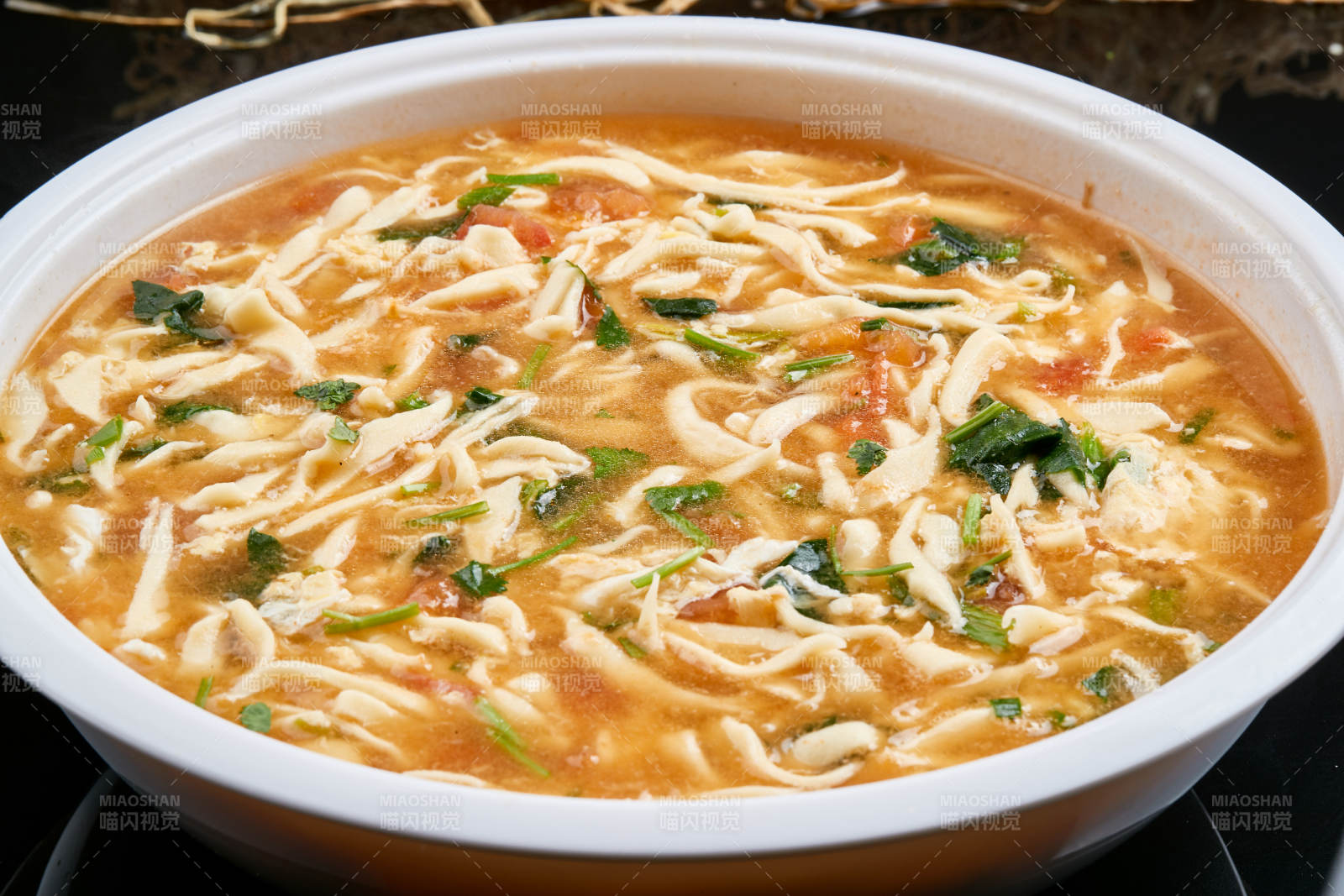 白色瓷盘装的西红柿鸡蛋白面拨鱼汤图片