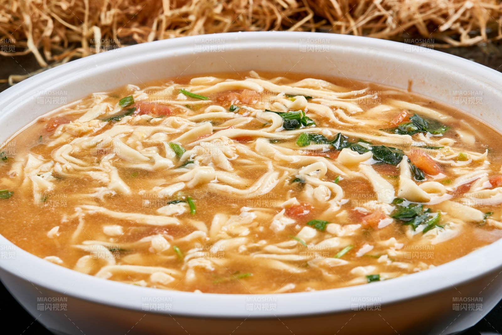 白色瓷盘装的西红柿鸡蛋白面拨鱼汤图片