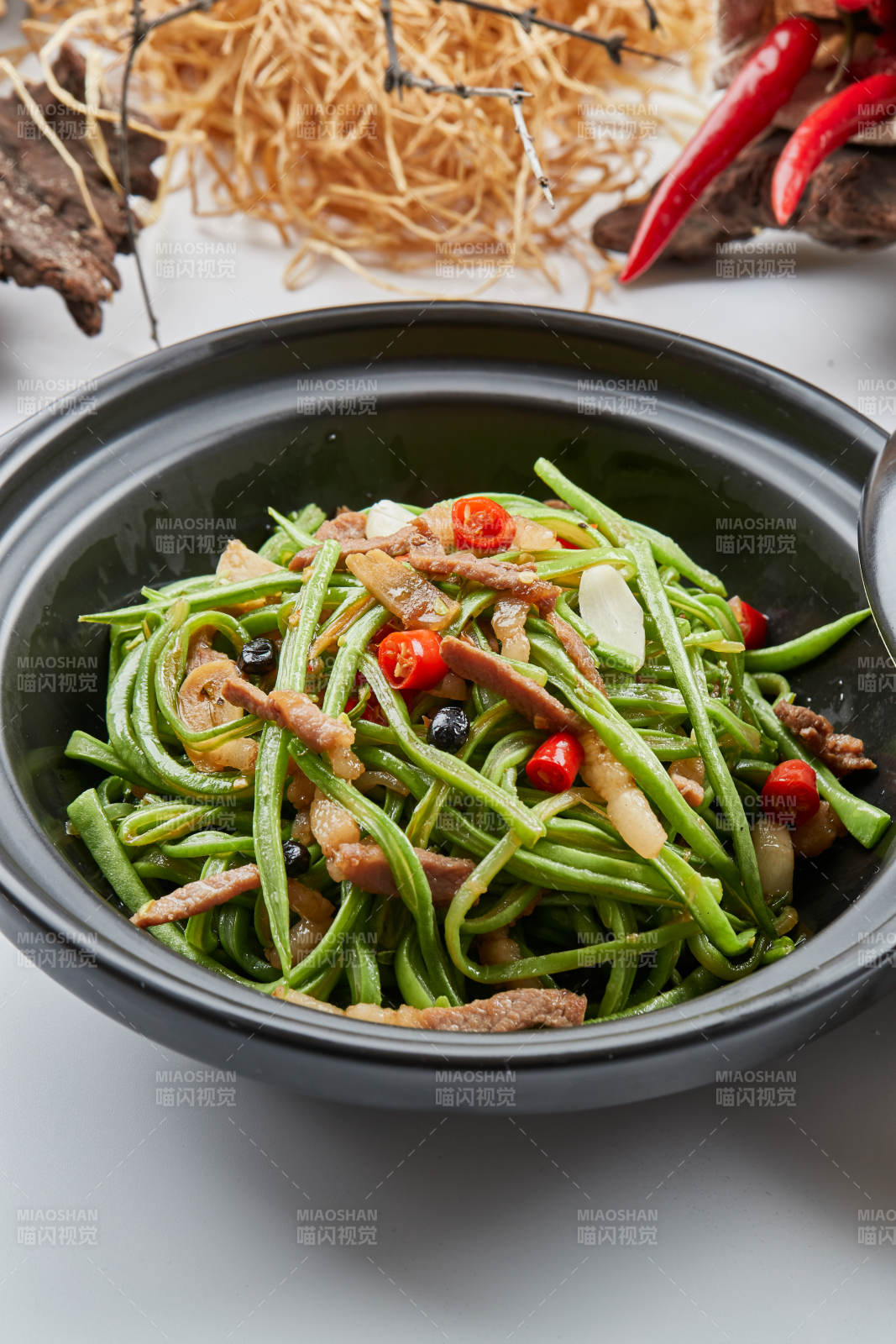 黑色砂锅装的米椒肉丝煲豇豆丝图片