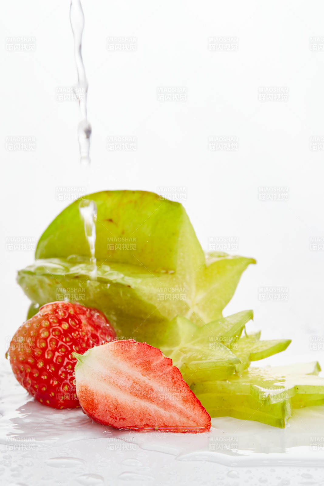 白色背景上摆放的新鲜洋桃和草莓及切片图片