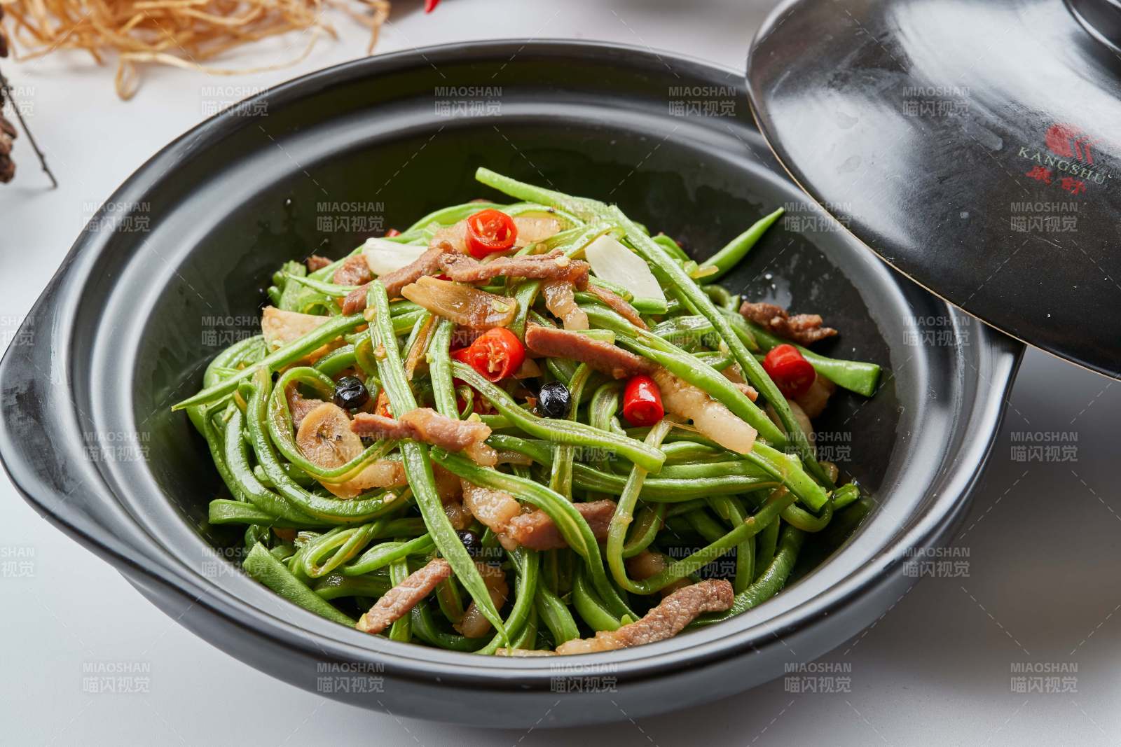 黑色砂锅装的米椒肉丝煲豇豆丝图片
