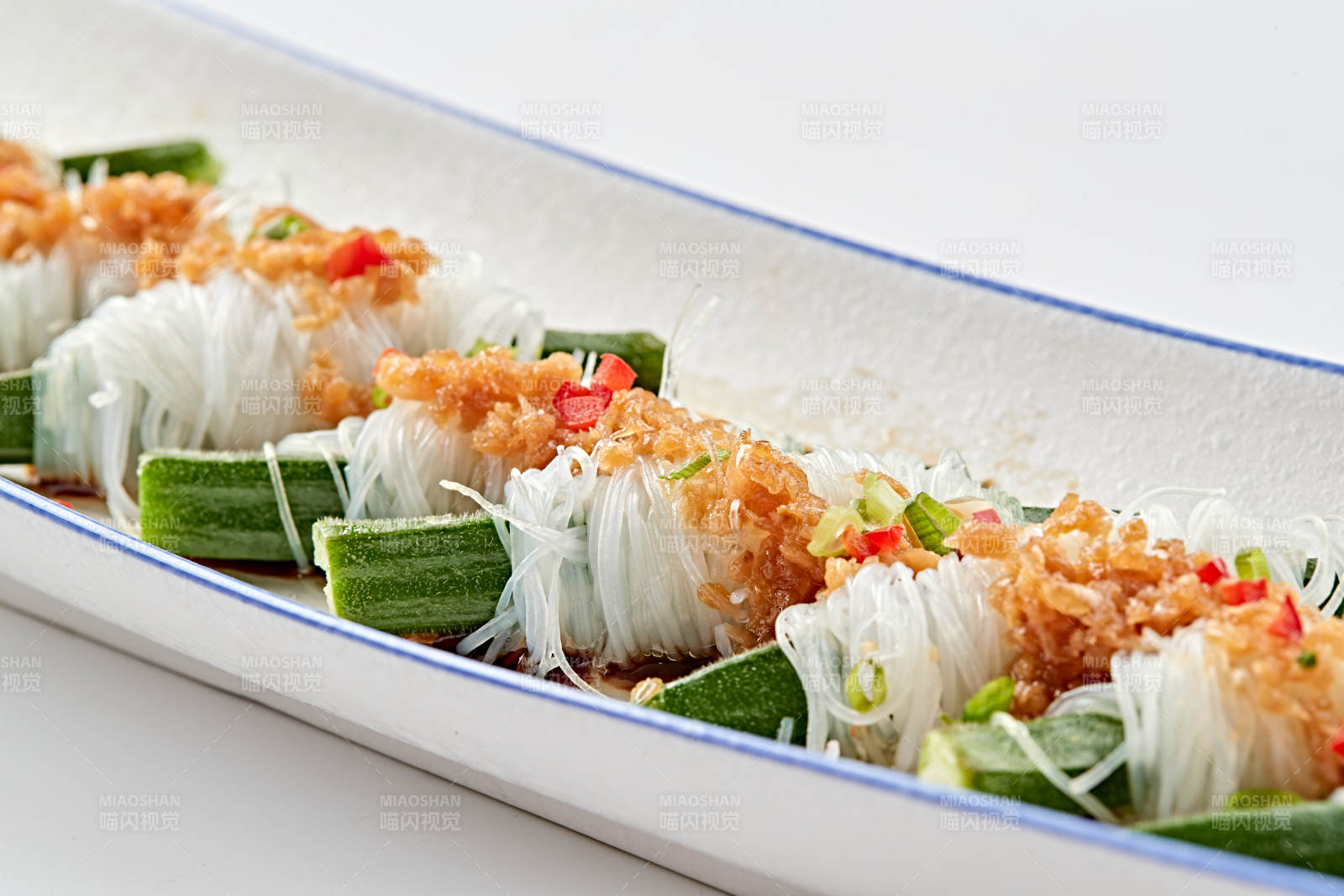 白色瓷盘装的蒜蓉粉丝蒸秋葵图片