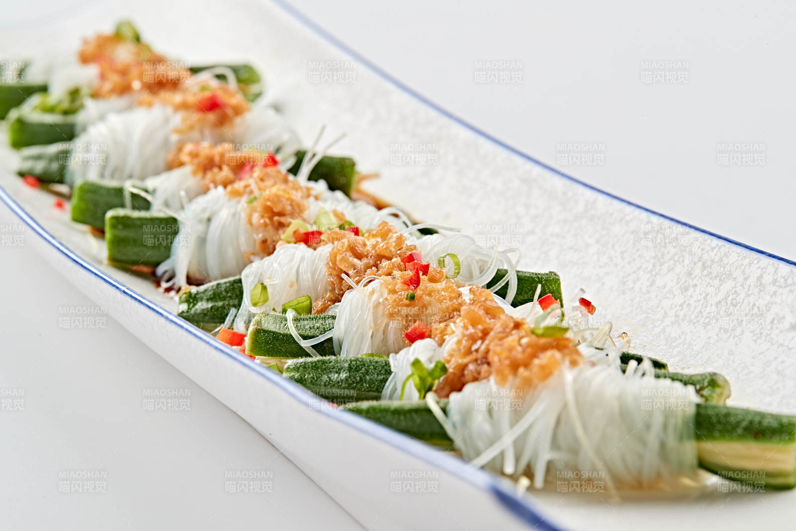 白色瓷盘装的蒜蓉粉丝蒸秋葵图片