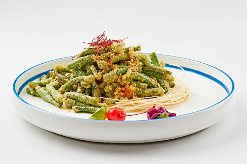 白色瓷盘装的咸蛋黄焗四季豆图片