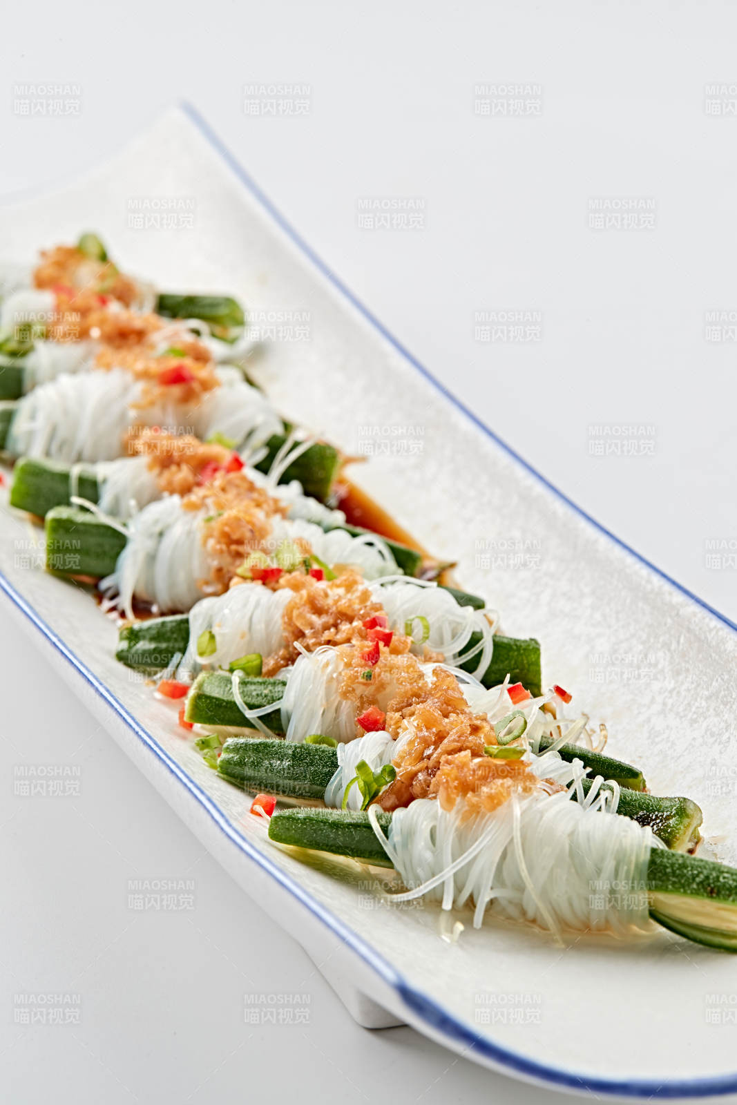 白色瓷盘装的蒜蓉粉丝蒸秋葵图片