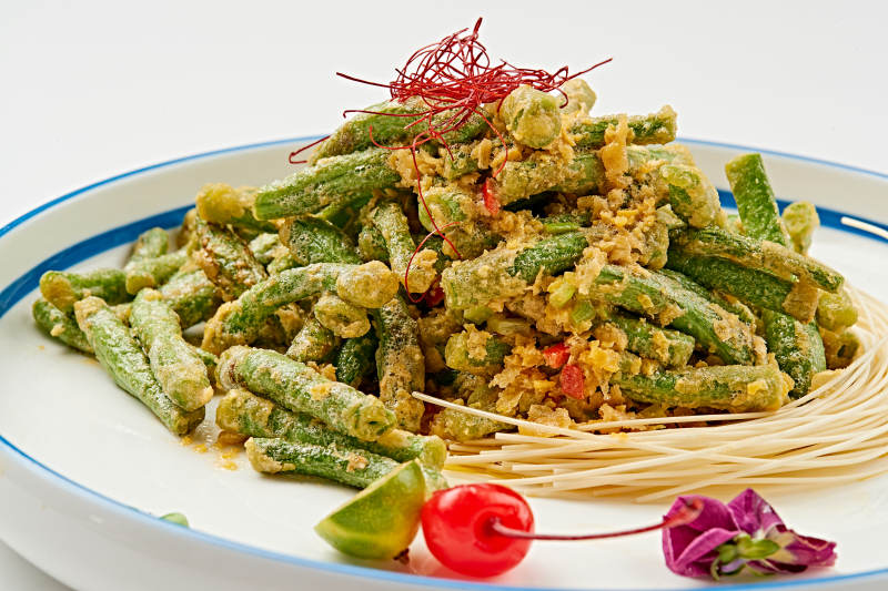 白色瓷盘装的咸蛋黄焗四季豆图片