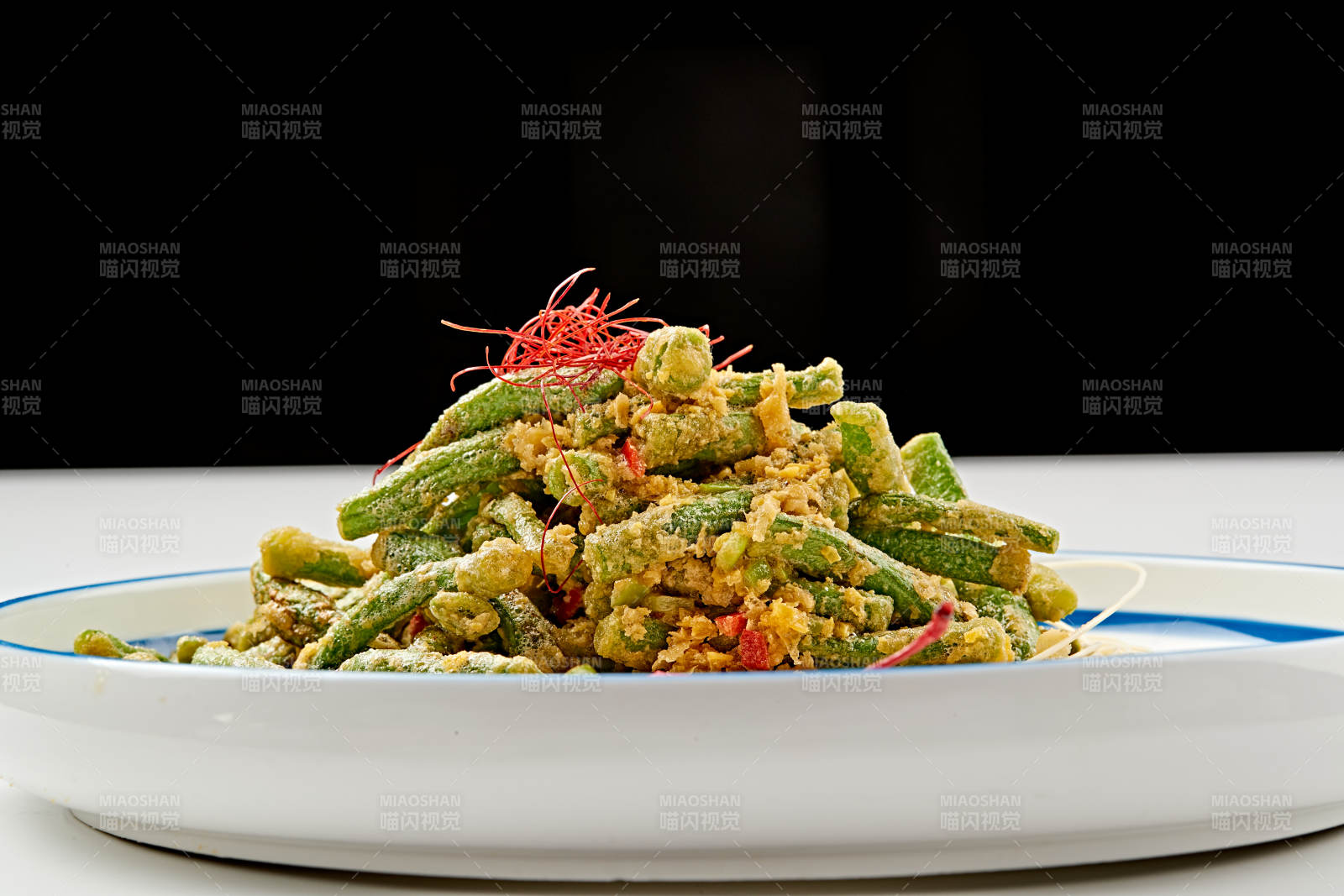 白色瓷盘装的咸蛋黄焗四季豆图片