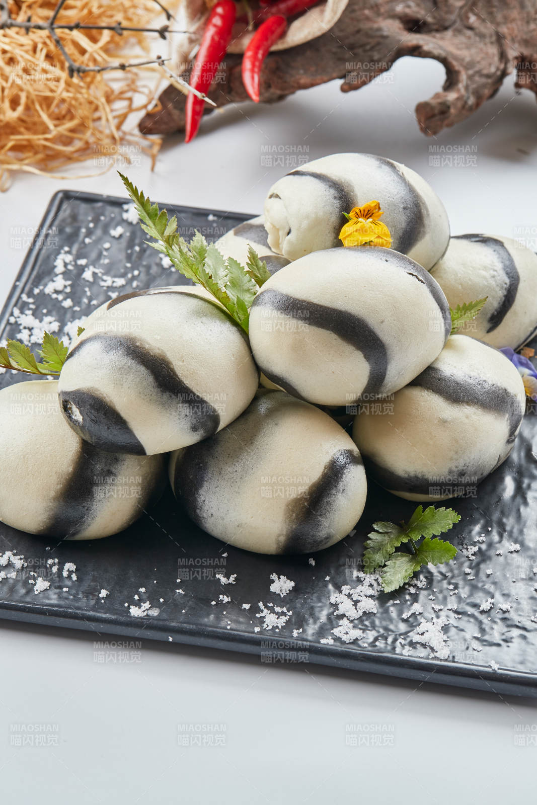 黑色瓷餐具装的大理石馒头图片