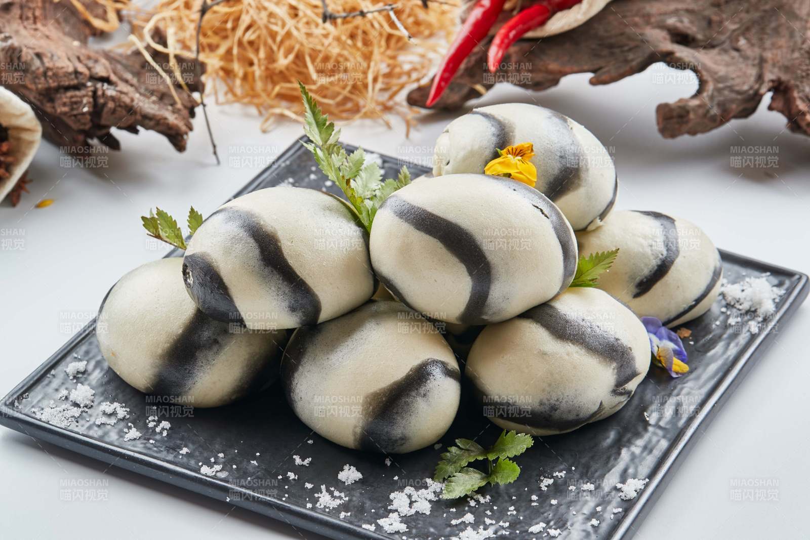 黑色瓷餐具装的大理石馒头图片