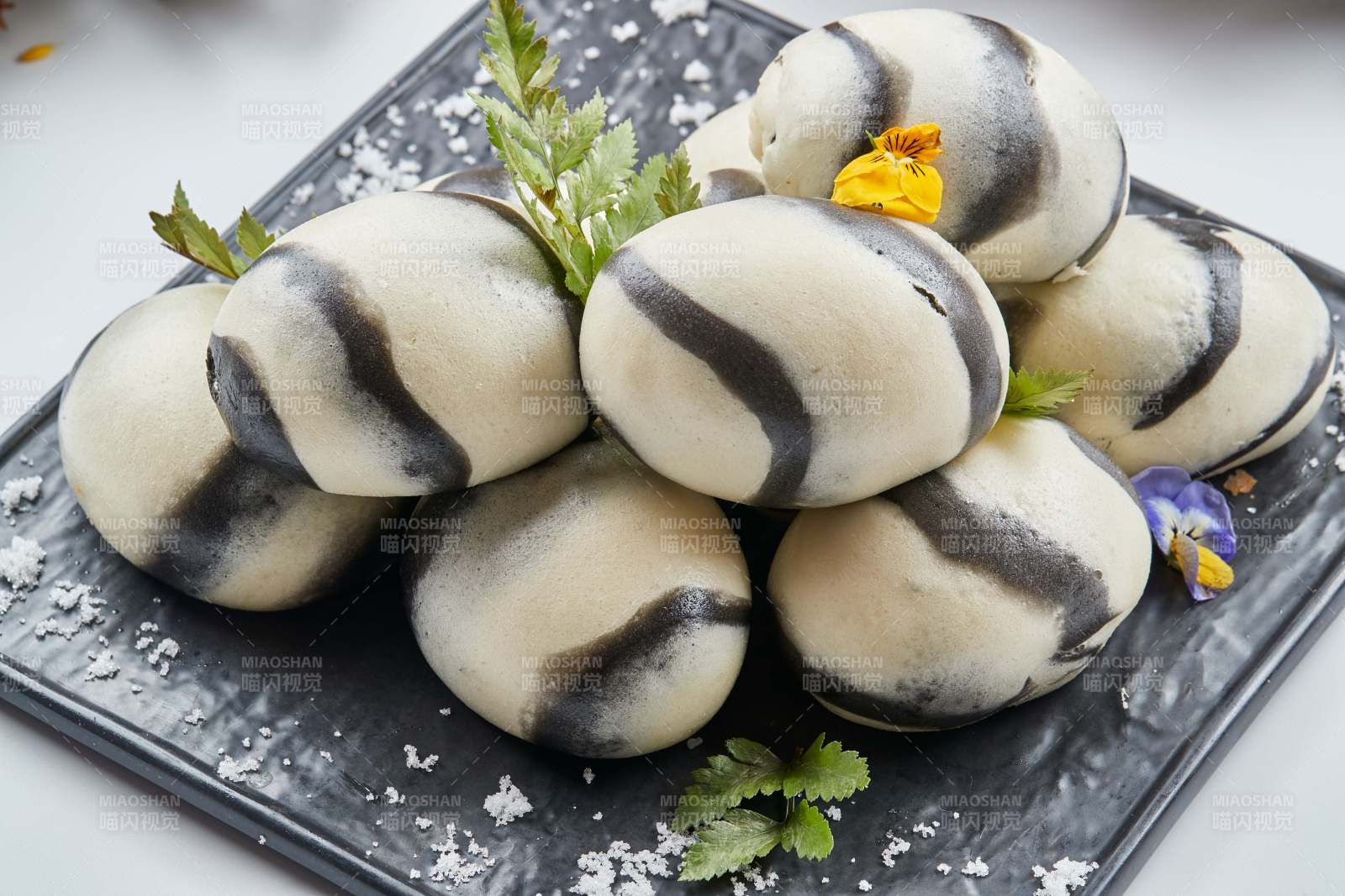 黑色瓷餐具装的大理石馒头图片