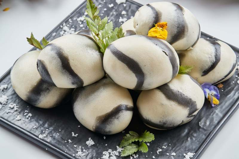 黑色瓷餐具装的大理石馒头图片