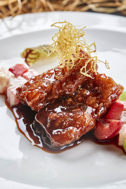 白色圆瓷盘装的浇汁香炸龙利鱼图片