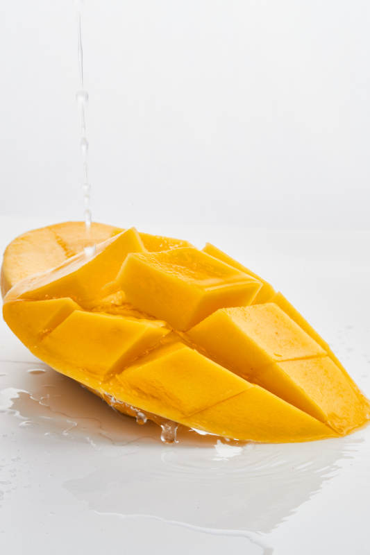 白色背景上摆放的水嫩新鲜芒果图片