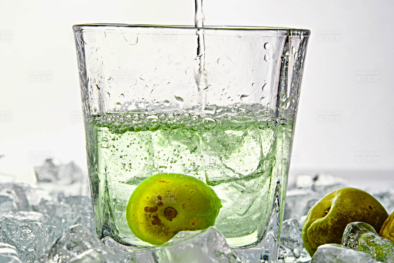 布满冰块的酒杯中的清凉白葡萄味预调酒图片