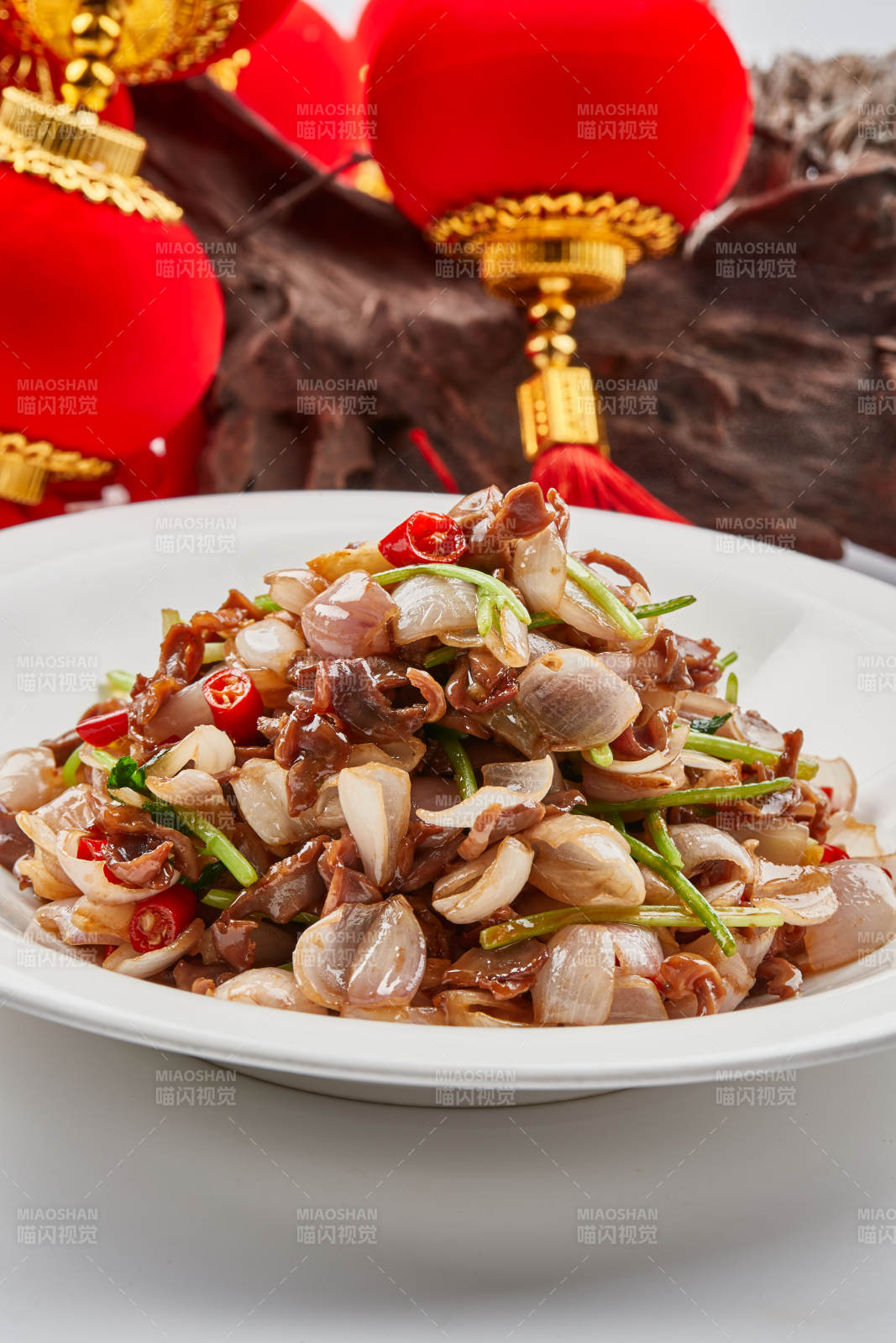 白色瓷盘装的小洋葱炒牛肉图片