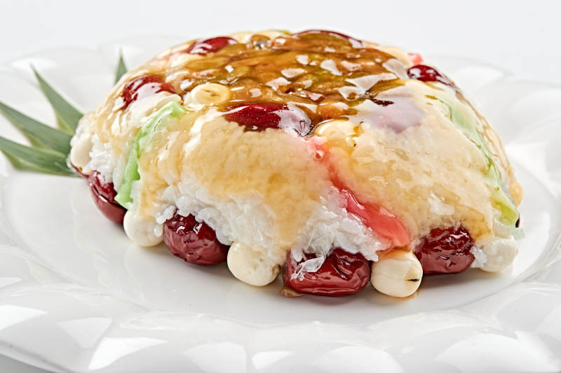 白色瓷盘装的婚宴甜品糯米八宝饭图片