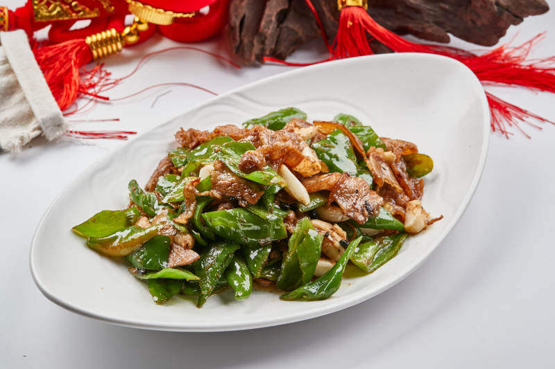 白色瓷盘装的杭椒小炒肉图片