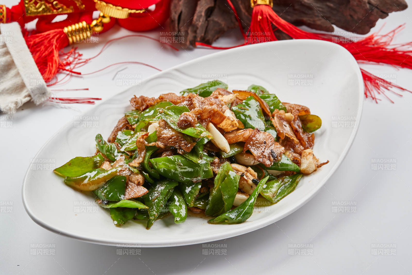 白色瓷盘装的杭椒小炒肉图片