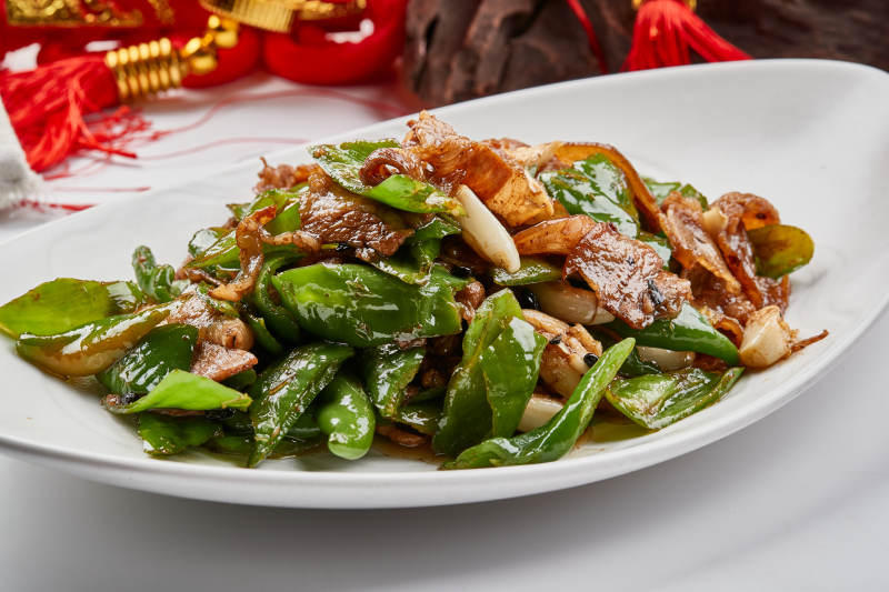 白色瓷盘装的杭椒小炒肉图片