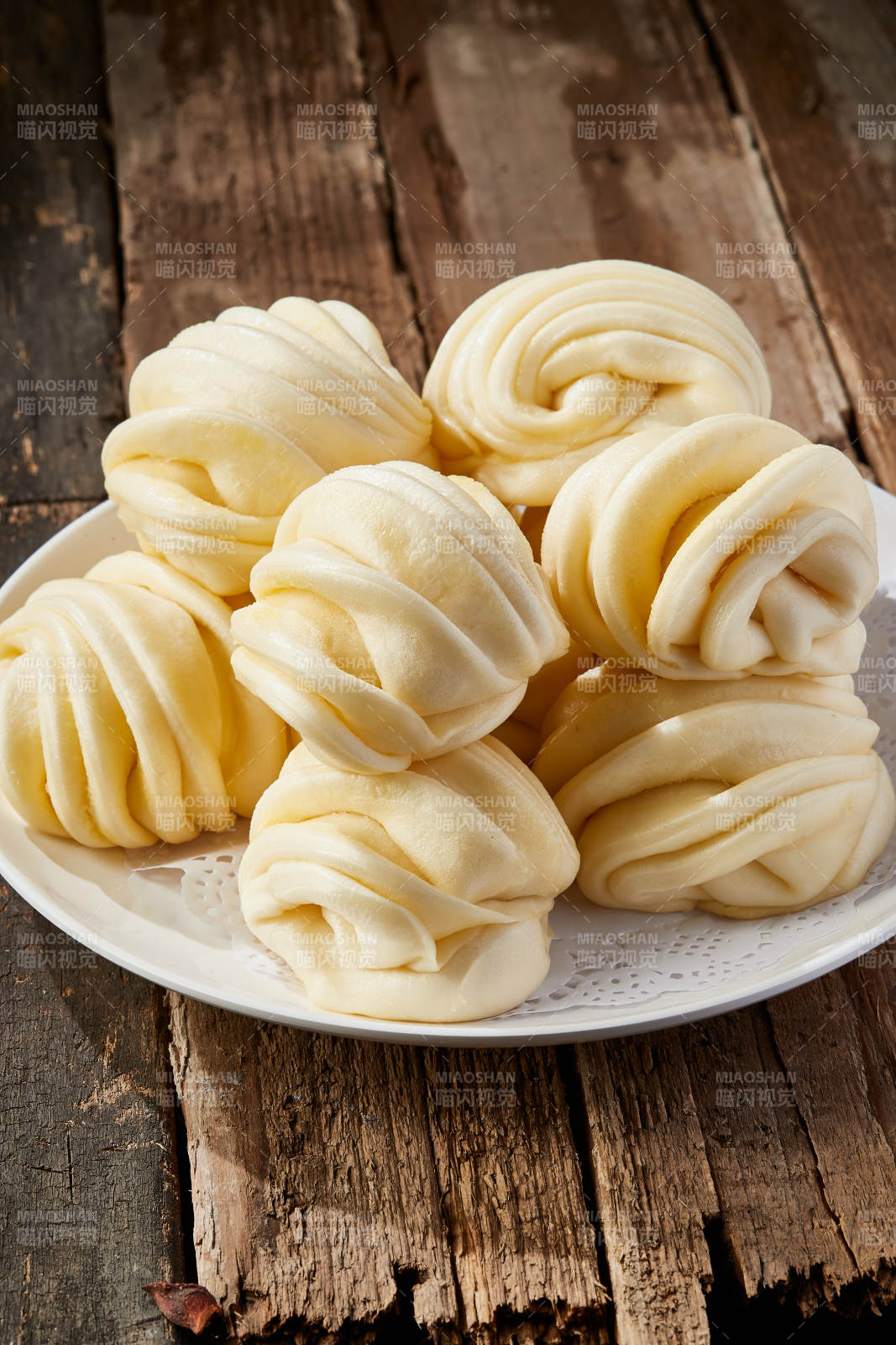 白色瓷盘装的现蒸麻油花卷图片