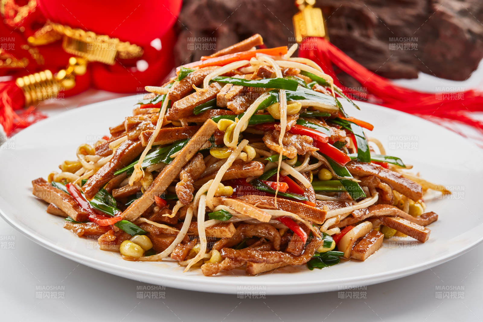 白色瓷盘装的彩椒丝黄豆芽拌香干图片