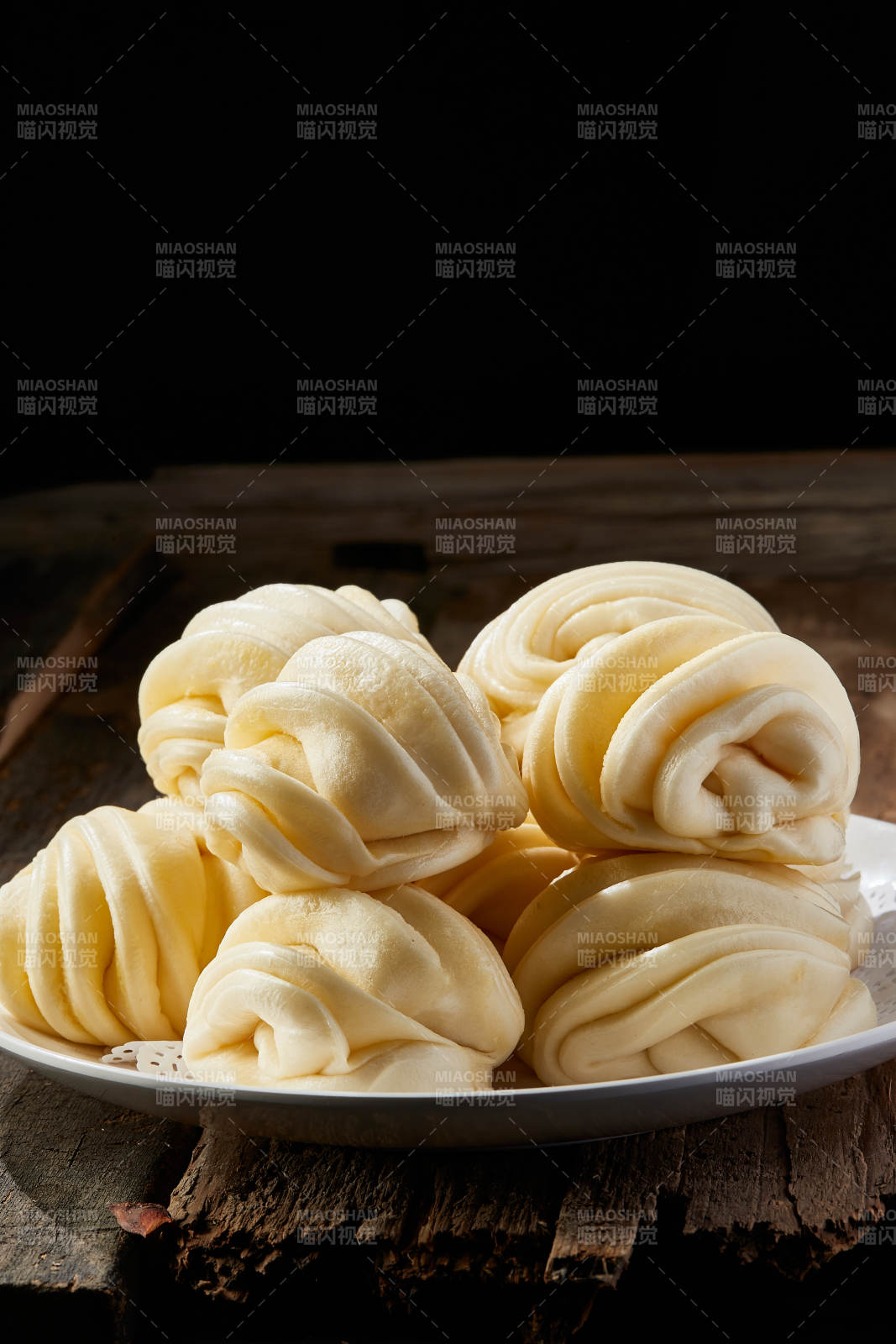 白色瓷盘装的现蒸麻油花卷图片