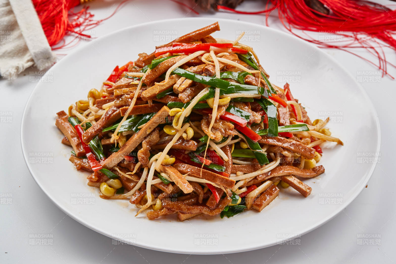白色瓷盘装的彩椒丝黄豆芽拌香干图片