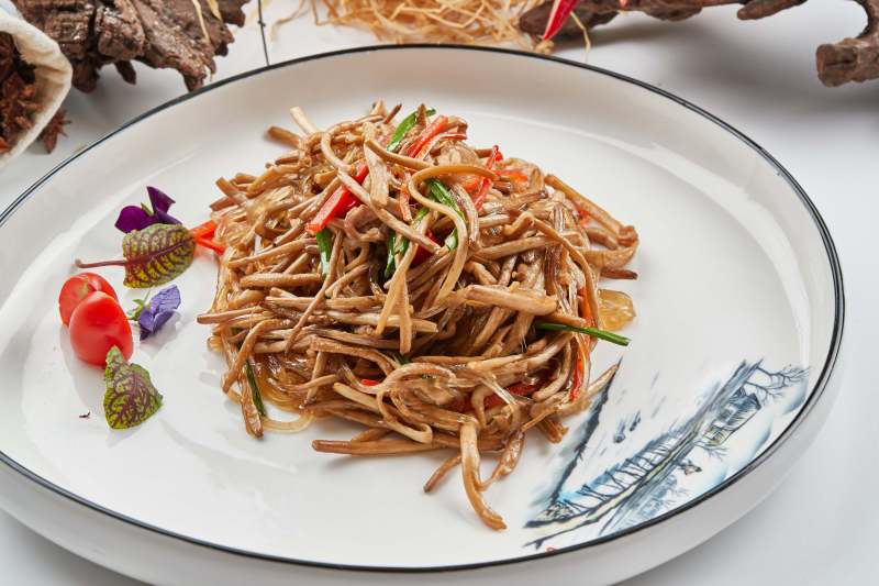 白色瓷餐具装的小米辣炝炒茶树菇图片