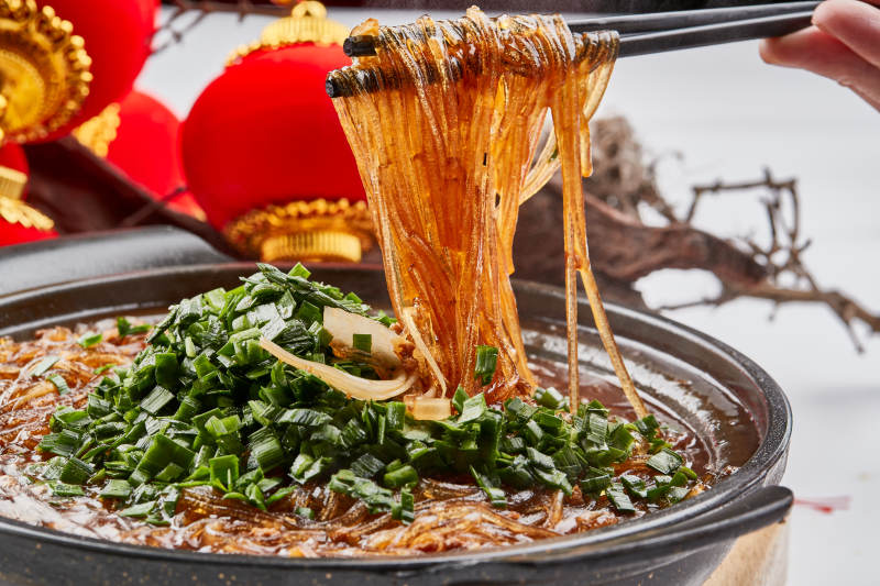 黑色砂锅装的水晶卤汤红薯粉图片