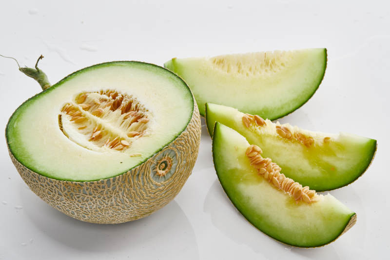 白色背景上摆放的新鲜哈密瓜图片