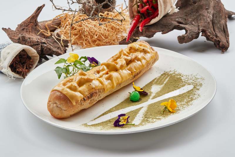 白色瓷盘装的的芝士火腿焗法棍面包图片