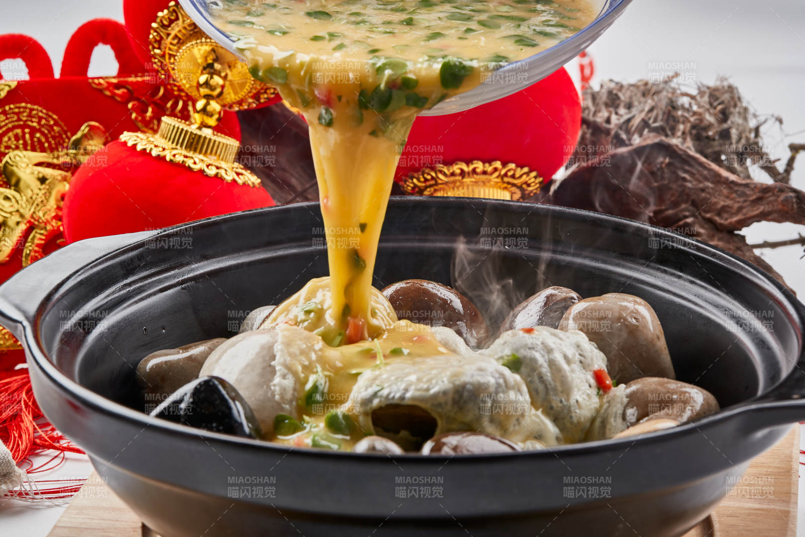 黑色砂锅装的创意美食鸡蛋碰石头图片