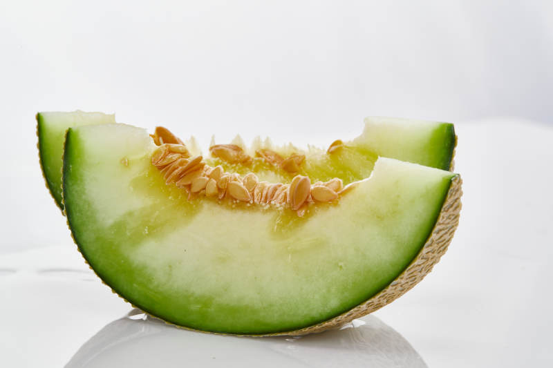 白色背景上摆放的新鲜哈密瓜图片