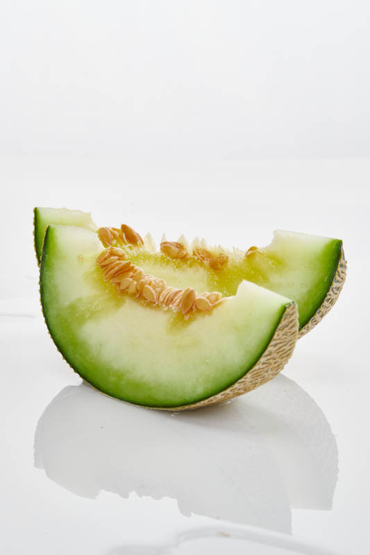 白色背景上摆放的新鲜哈密瓜图片