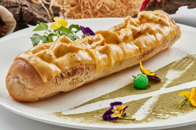 白色瓷盘装的的芝士火腿焗法棍面包图片