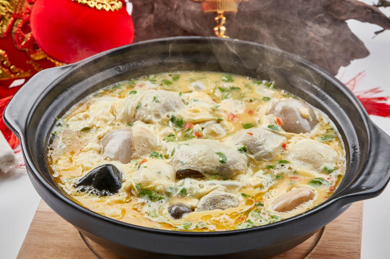 黑色砂锅装的创意美食鸡蛋碰石头图片