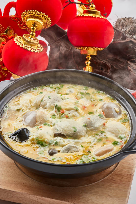 黑色砂锅装的创意美食鸡蛋碰石头图片