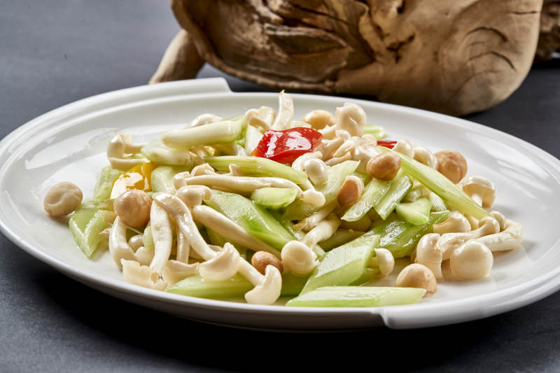圆瓷盘装的西芹彩椒小炒白玉菇图片