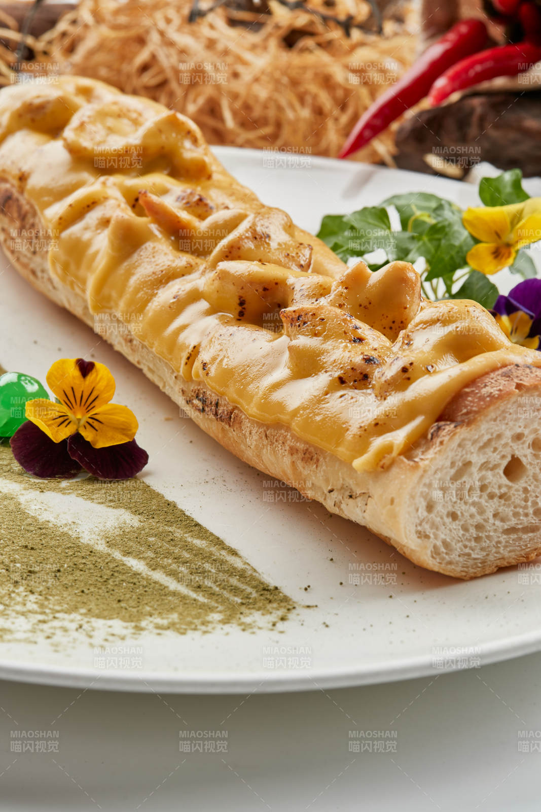 白色瓷盘装的的芝士火腿焗法棍面包图片