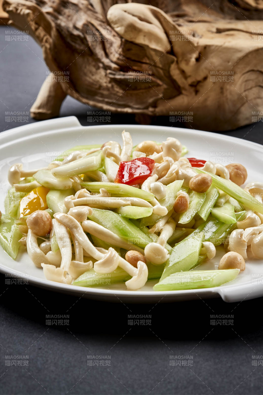 圆瓷盘装的西芹彩椒小炒白玉菇图片