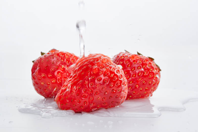 白色背景上摆放的水嫩新鲜草莓图片