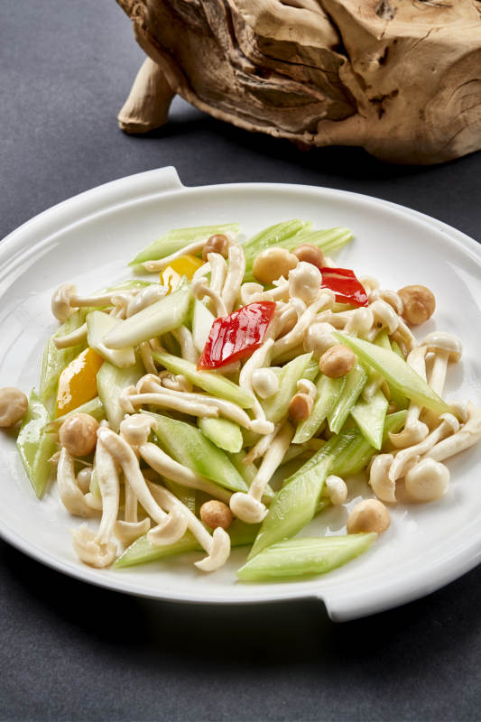 圆瓷盘装的西芹彩椒小炒白玉菇图片