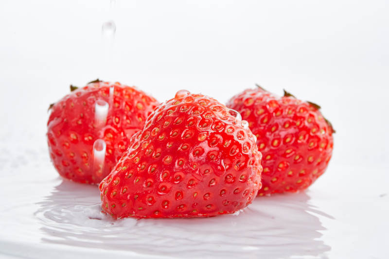 白色背景上摆放的水嫩新鲜草莓图片
