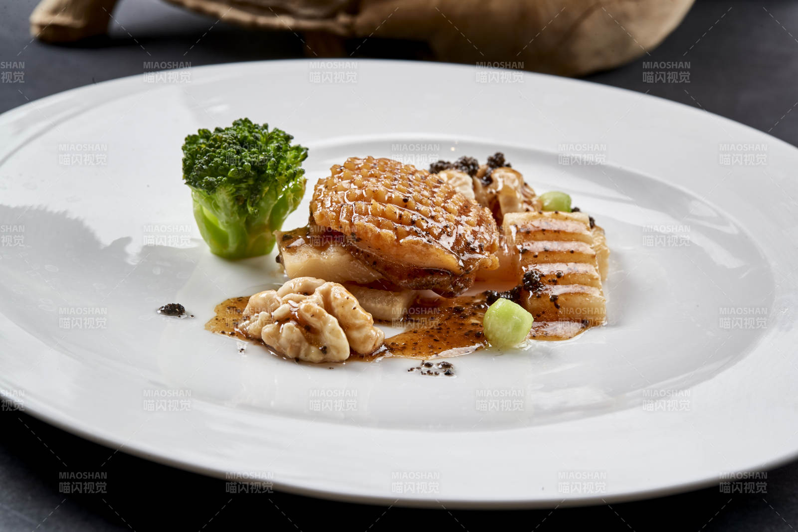 白色圆瓷盘装的黑胡椒桃仁大连鲍图片