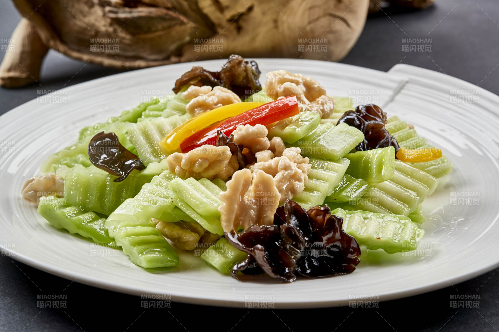 圆瓷盘装的乳瓜桃仁彩椒炒木耳图片