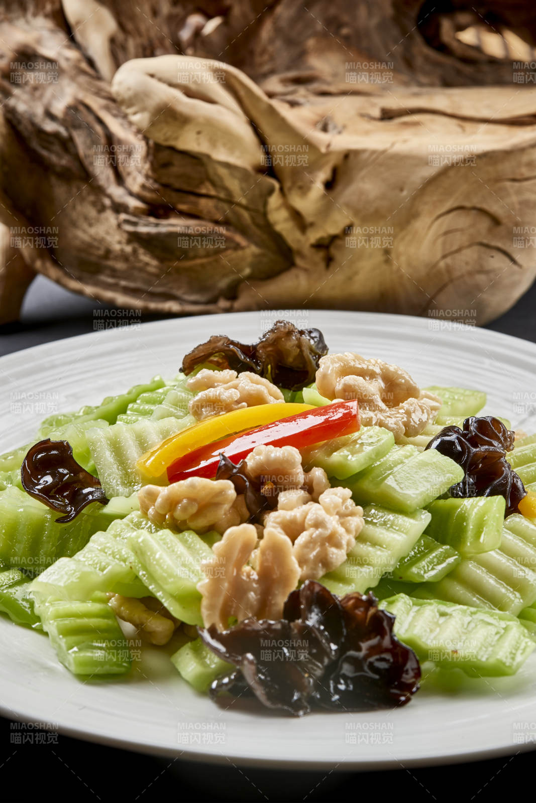 圆瓷盘装的乳瓜桃仁彩椒炒木耳图片
