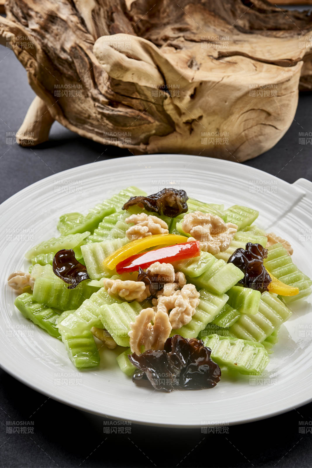 圆瓷盘装的乳瓜桃仁彩椒炒木耳图片